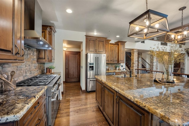 12570 W 60th Ave, Arvada, CO 80004 - kitchen with appliances with stainless steel finishes, wall chimney exhaust hood, a sink, backsplash, and brown cabinetry