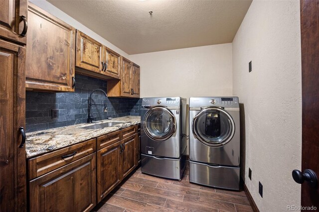 12570 W 60th Ave, Arvada, CO 80004 - washroom with separate washer and dryer, cabinet space, wood tiled floors, a textured ceiling, and a textured wall