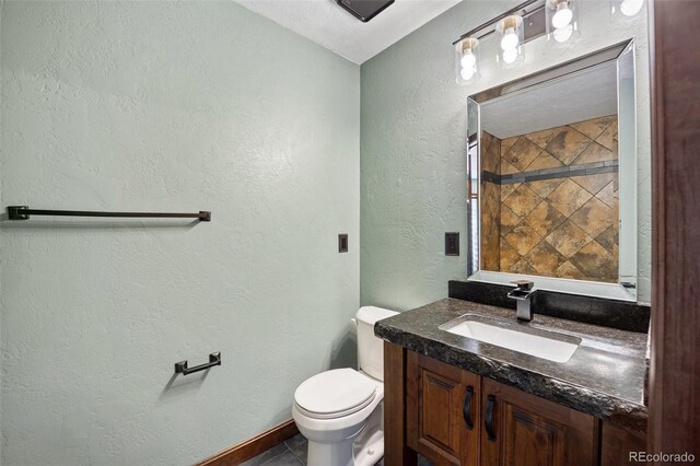 12570 W 60th Ave, Arvada, CO 80004 - bathroom with vanity, a textured wall, toilet, tile patterned flooring, and baseboards