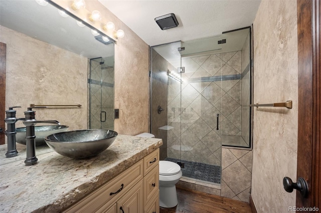 12570 W 60th Ave, Arvada, CO 80004 - bathroom with toilet, vanity, a shower stall, and wood finished floors
