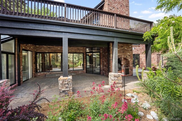 12570 W 60th Ave, Arvada, CO 80004 - rear view of house featuring a patio area, brick siding, and a fireplace