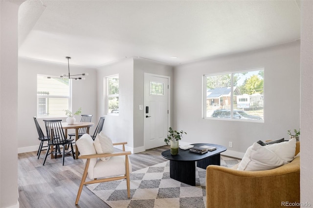 living room featuring an inviting chandelier, light hardwood / wood-style floors, and plenty of natural light