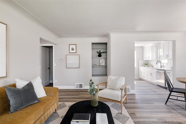 living room featuring sink and light wood-type flooring