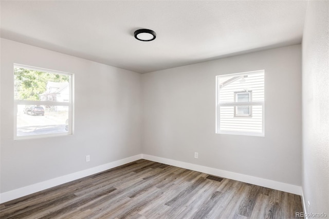 unfurnished room with wood-type flooring