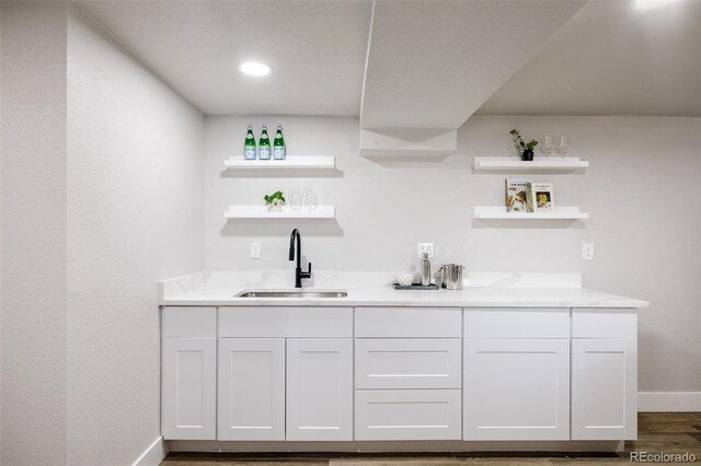 bar featuring sink, dark hardwood / wood-style floors, and white cabinets