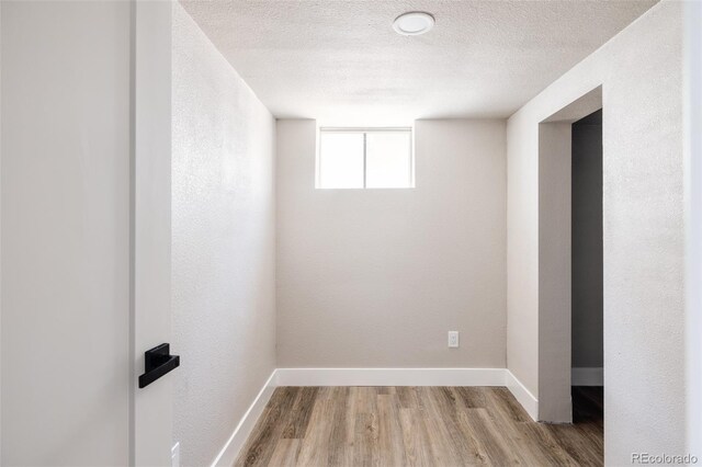 spare room featuring a textured ceiling and hardwood / wood-style flooring