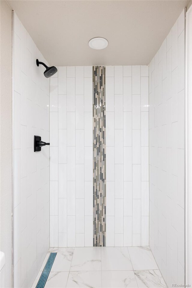 bathroom with tile patterned floors and a tile shower