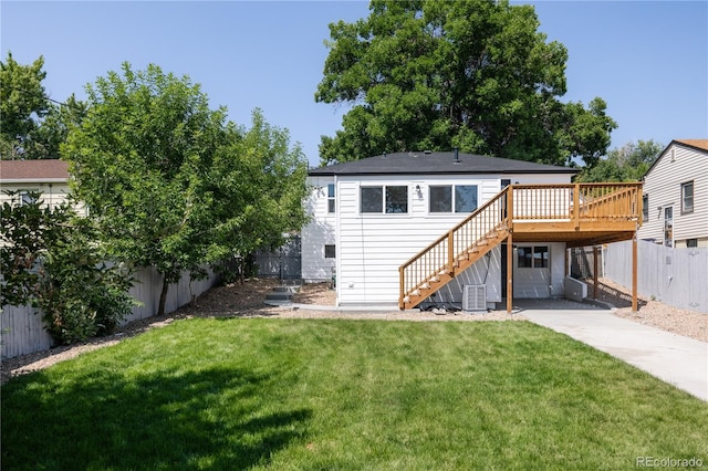 back of property with central AC unit, a yard, and a wooden deck