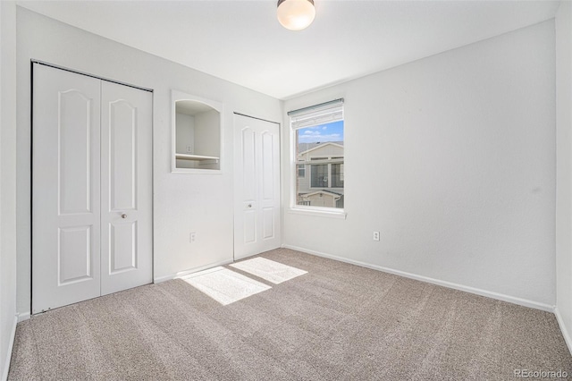 unfurnished bedroom with multiple closets and carpet floors