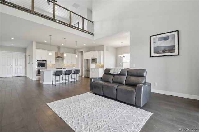 8803 Antero Ct, Arvada, CO 80007 - living room featuring dark wood-type flooring, recessed lighting, baseboards, a chandelier, and a towering ceiling