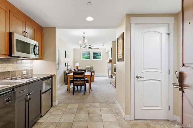 kitchen with backsplash, light carpet, hanging light fixtures, ceiling fan, and appliances with stainless steel finishes