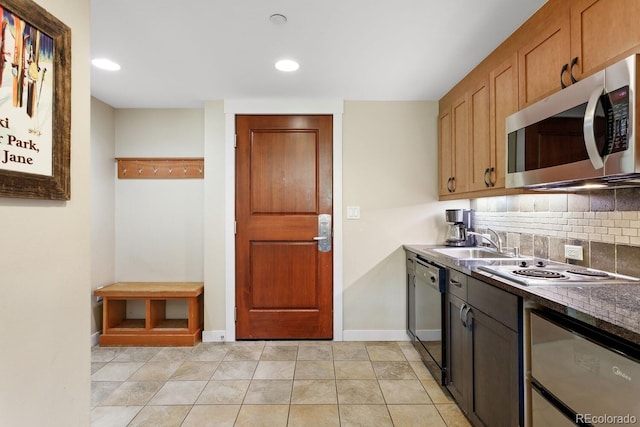 kitchen featuring decorative backsplash, sink, light tile patterned floors, and stainless steel appliances