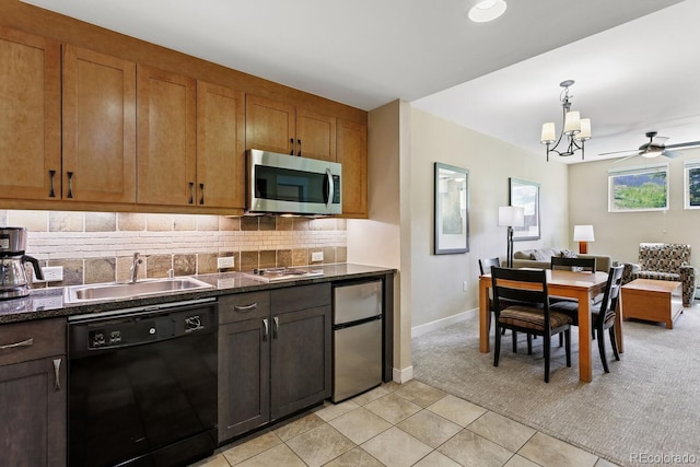 kitchen with decorative backsplash, refrigerator, sink, light tile patterned floors, and black dishwasher