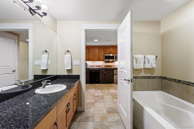 bathroom with a textured ceiling, vanity, tile patterned floors, and a tub