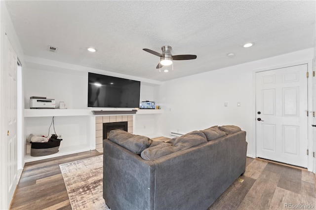 12119 Forest St, Thornton, CO 80241 - living room with ceiling fan, wood finished floors, recessed lighting, a baseboard heating unit, and a tiled fireplace