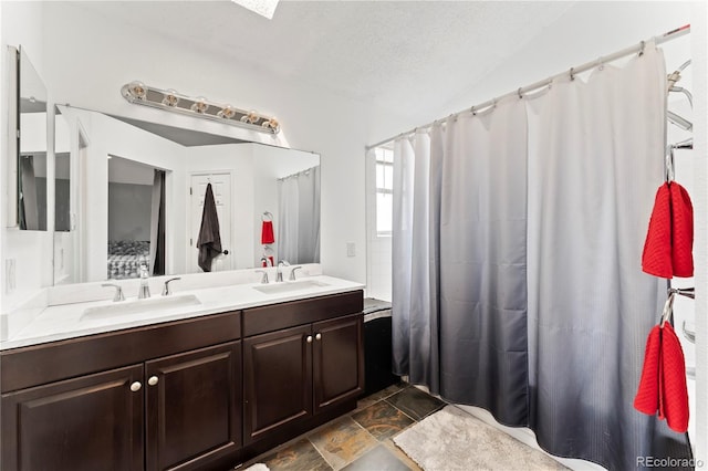 12119 Forest St, Thornton, CO 80241 - bathroom with double vanity, lofted ceiling, and a textured ceiling