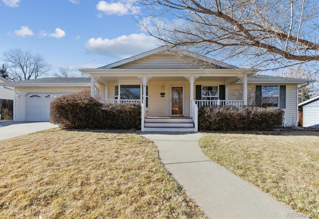 view of front of property with a front yard, a porch, and a garage