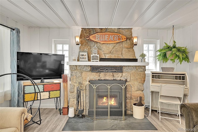 living room featuring a stone fireplace and wood finished floors