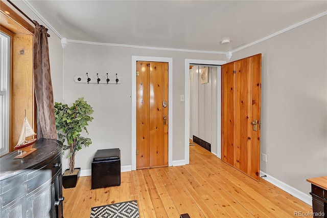 interior space with crown molding, light wood finished floors, and baseboards