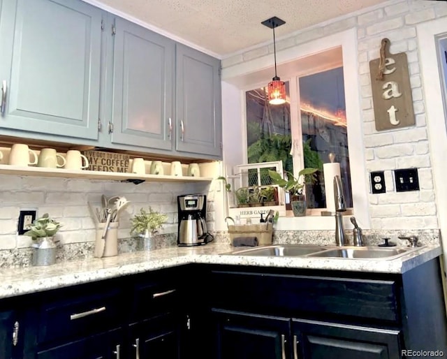 bar with tasteful backsplash, a textured ceiling, pendant lighting, and a sink