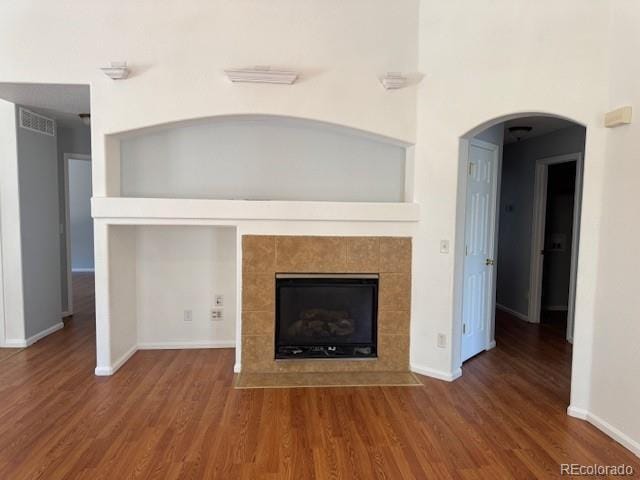 20148 E Dartmouth Dr, Aurora, CO 80013 - unfurnished living room featuring a fireplace, wood finished floors, baseboards, and arched walkways