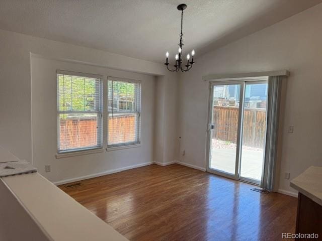 20148 E Dartmouth Dr, Aurora, CO 80013 - unfurnished dining area featuring wood finished floors, a chandelier, plenty of natural light, baseboards, and vaulted ceiling