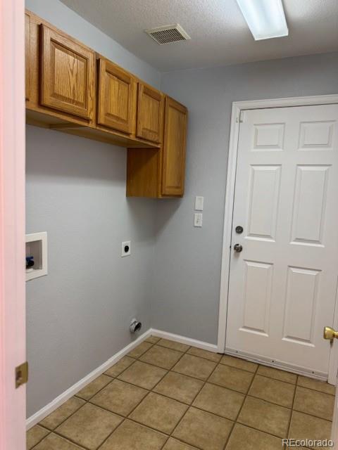 20148 E Dartmouth Dr, Aurora, CO 80013 - laundry room with cabinet space, electric dryer hookup, hookup for a washing machine, light tile patterned floors, and baseboards