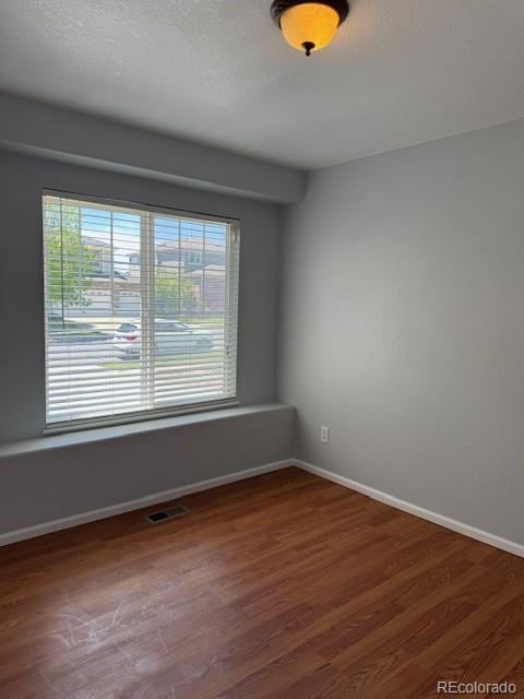 20148 E Dartmouth Dr, Aurora, CO 80013 - unfurnished room with plenty of natural light, wood finished floors, and baseboards