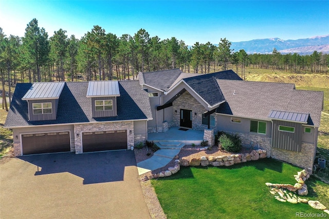 view of front of property featuring a garage, a mountain view, and a front lawn