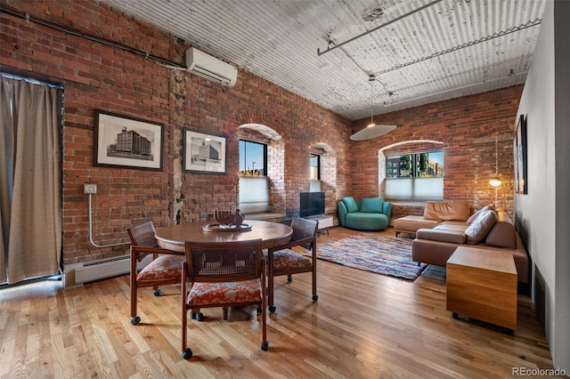 dining room with hardwood / wood-style flooring, a towering ceiling, and an AC wall unit