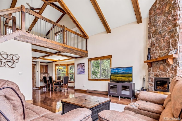 1424 Bluestem Way, Fairplay, CO 80440 - living room with high vaulted ceiling, wood finished floors, beamed ceiling, a stone fireplace, and a baseboard radiator