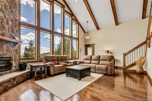 1424 Bluestem Way, Fairplay, CO 80440 - living room with high vaulted ceiling, hardwood / wood-style floors, beamed ceiling, stairway, and a fireplace
