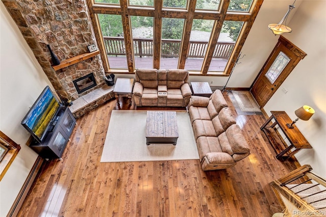 1424 Bluestem Way, Fairplay, CO 80440 - living area with hardwood / wood-style flooring, healthy amount of natural light, a high ceiling, and a stone fireplace