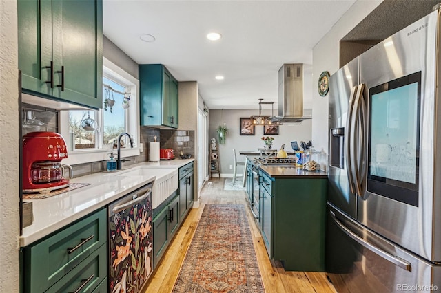 kitchen with light wood-style floors, stainless steel appliances, island exhaust hood, and green cabinets