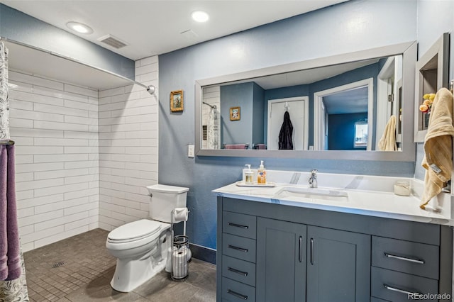 bathroom with toilet, visible vents, a tile shower, and vanity