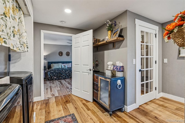 kitchen featuring light wood finished floors, washing machine and dryer, baseboards, and open shelves