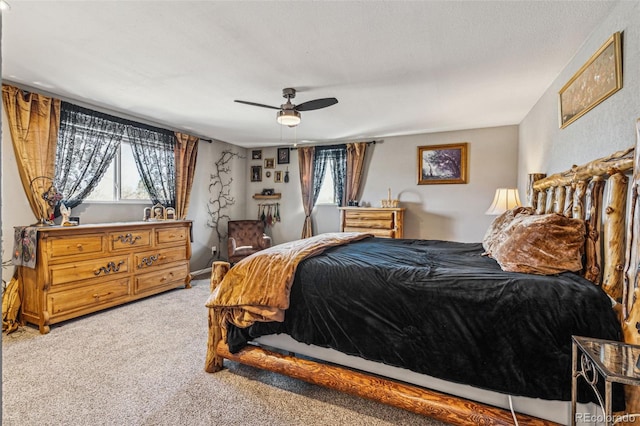 carpeted bedroom featuring a textured ceiling, multiple windows, and a ceiling fan