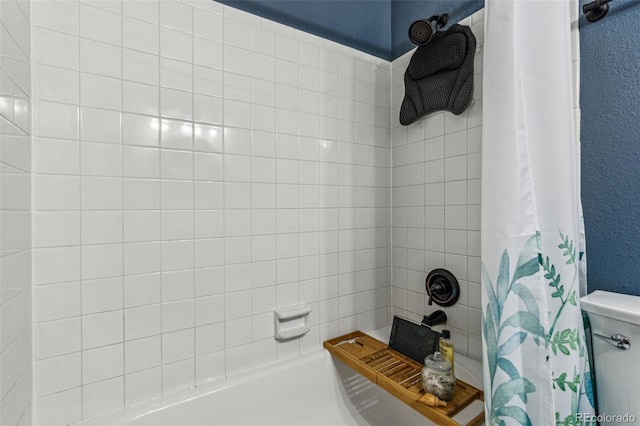 bathroom featuring shower / bath combination with curtain and a textured wall