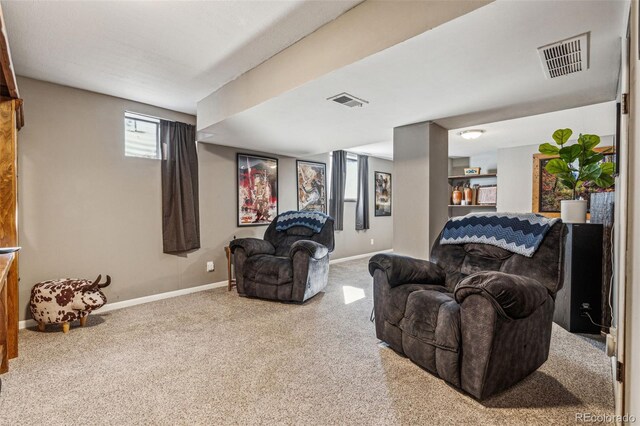 carpeted living area featuring visible vents and baseboards