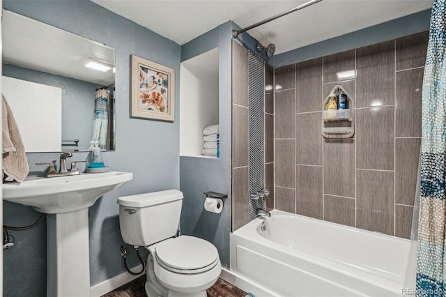 bathroom featuring toilet, shower / bath combo, and baseboards