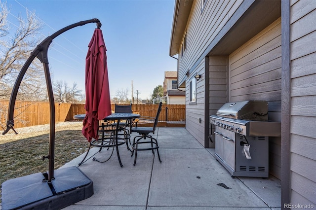 view of patio with outdoor dining area, a fenced backyard, and grilling area