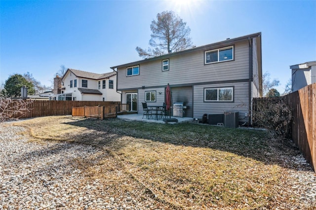 rear view of house with a patio area, a fenced backyard, cooling unit, and a yard