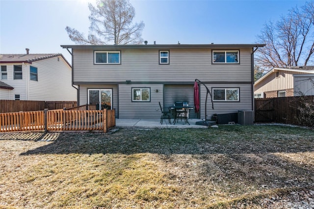 rear view of house featuring a yard, a fenced backyard, a patio, and central AC