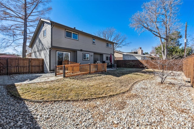 rear view of property featuring a fenced backyard