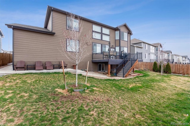rear view of property featuring a patio area, stairway, fence, and a lawn