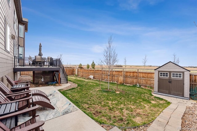 view of yard with stairs, a storage shed, an outdoor structure, and a fenced backyard