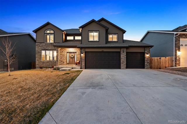 view of front of property with concrete driveway, stone siding, fence, and an attached garage
