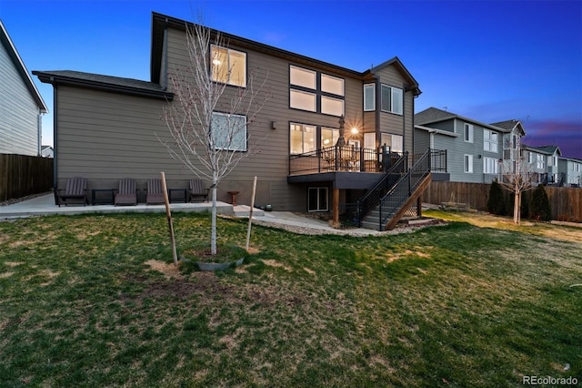 back of property featuring a lawn, a patio area, fence, and stairs