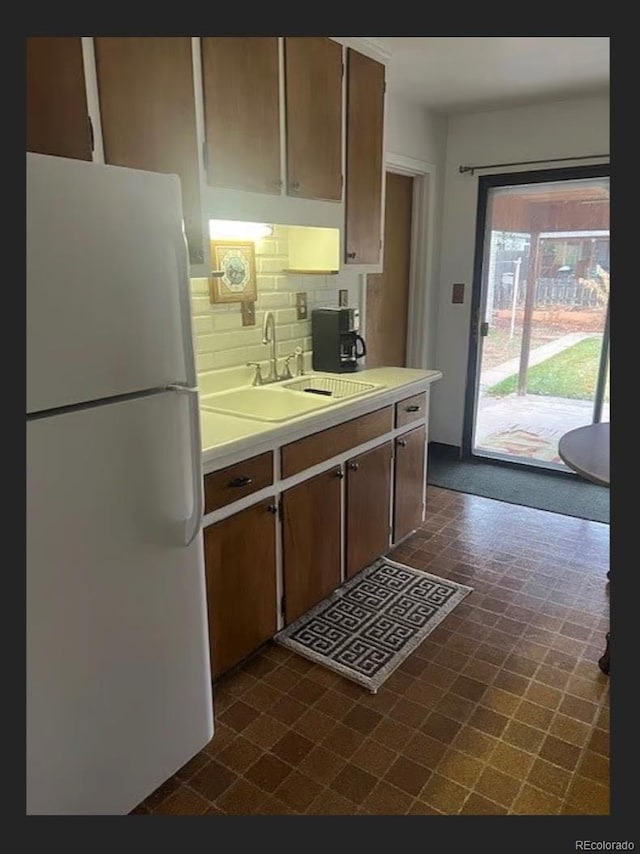 3905 Nelson St, Wheat Ridge, CO 80033 - kitchen with freestanding refrigerator, a sink, light countertops, tasteful backsplash, and dark flooring