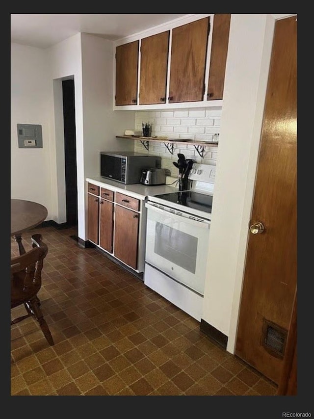 3905 Nelson St, Wheat Ridge, CO 80033 - kitchen featuring white electric range oven, stainless steel microwave, dark floors, and light countertops
